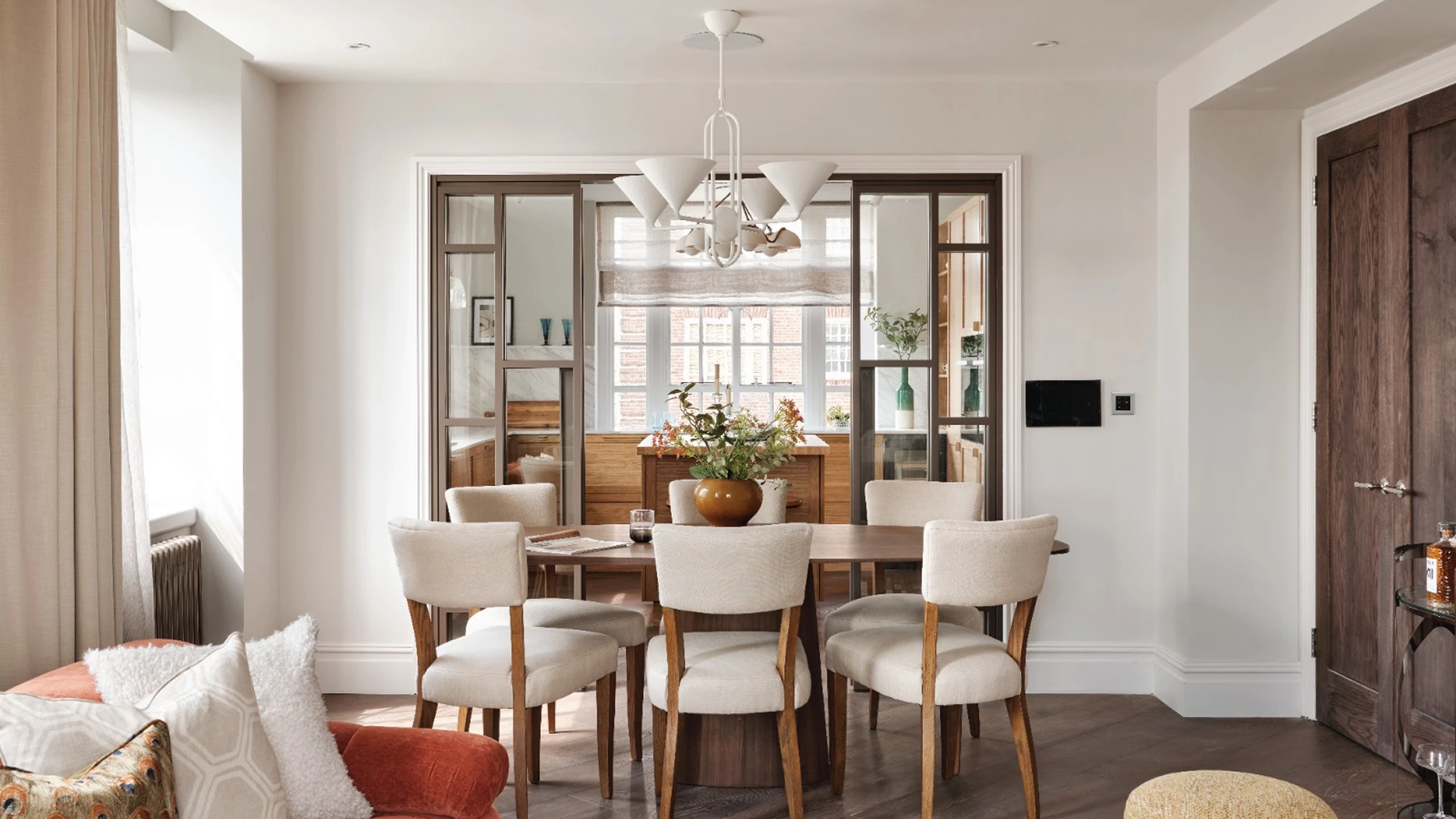 Elegant dining room with cream upholstered chairs and modern chandelier